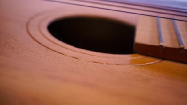 Движение взгляда вдоль изношенной акустической гитары — стоковое видео
