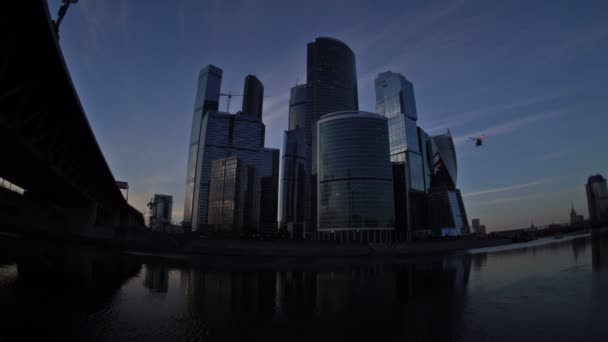 ヘリコプターは、日没時にモスクワ国際ビジネスセンター(モスクワ市)の高層ビルの前に着陸しています。魚眼レンズ。ウード - 4k。2016年9月01日モスクワ。ロシア — ストック動画