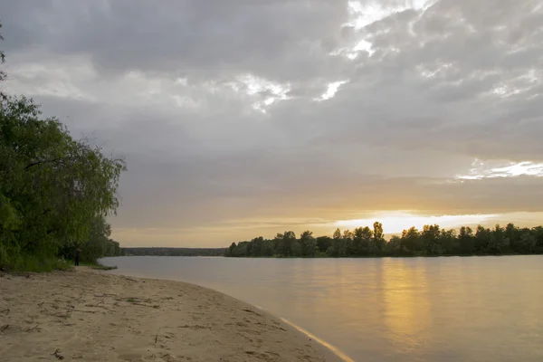 Strand am Fluss bei Sonnenuntergang mit Bäumen — Stockfoto