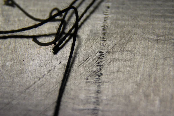 gri bir arka plan üzerinde siyah iplik