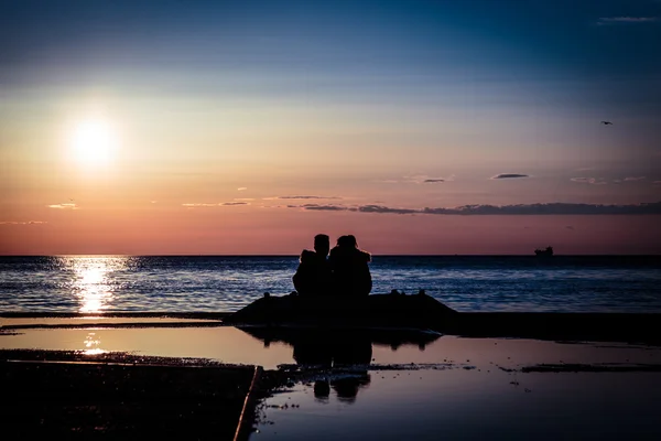 Couple watching a romantic sunset — Stock Photo, Image