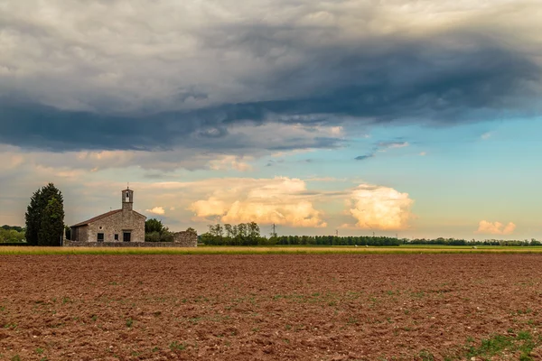 Storm reaching a little church in the fields — Stock Photo, Image