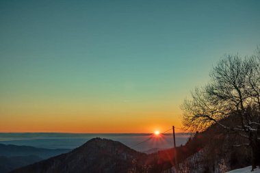 Slovenya ile İtalya arasındaki tepelerde gün batımı dondurucu bir kış günü