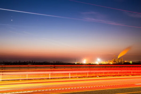 Le soleil se couche derrière une industrie — Photo