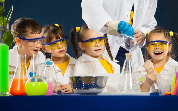 Šťastné děti s vědec dělá vědecké experimenty v laboratoři — Stock fotografie
