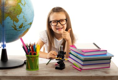 başparmak yukarıya ile dünya masasında otururken gösteren kız