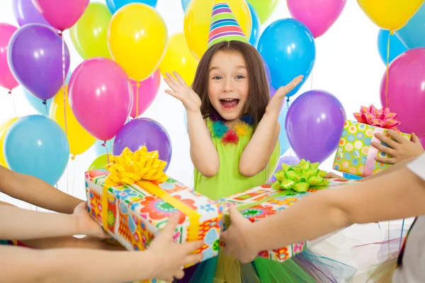 Joyful little kid girl receiving gifts at birthday party — Stock Photo, Image