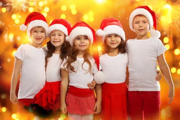 Glada barn i jul hatt med färgglada lampor på bakgrund — Stockfoto