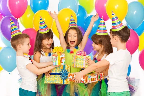 Joyeuse petite fille recevant des cadeaux à la fête d'anniversaire — Photo