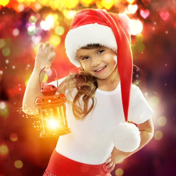 Niña en sombrero de Santa sosteniendo linterna roja de Navidad — Foto de Stock