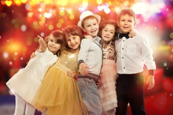 Grupo de niños felices con luces de colores en el fondo . — Foto de Stock