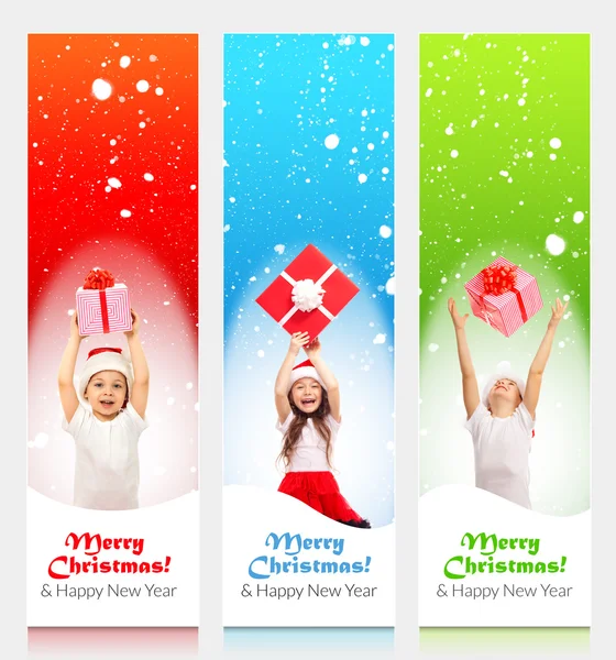 Glückliche kleine Kinder mit Weihnachtsmannmütze, die hinter einer leeren Werbetafel hervorlugen — Stockfoto