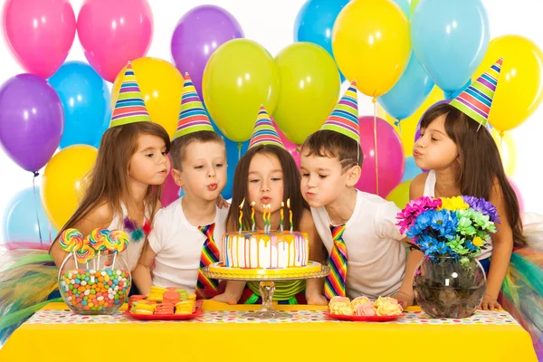 Kinder feiern Geburtstagsparty und pusten Kerzen auf Kuchen — Stockfoto