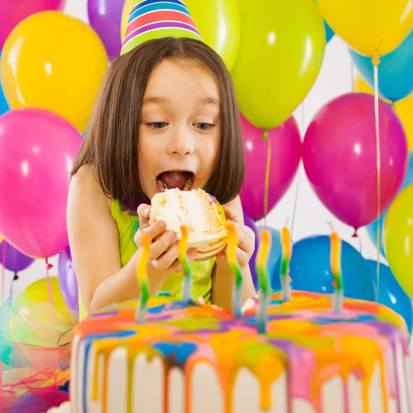Portrait of joyful little girl with cake at birthday party Stock Photo
