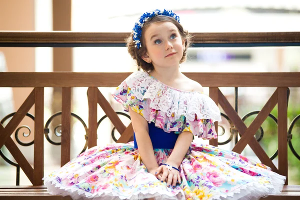 Portrait de petite fille branchée assise sur un banc — Photo