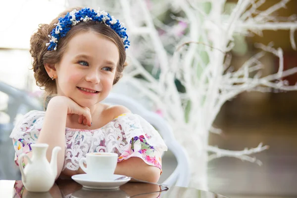 Портрет маленькой девочки в цветочном платье, пьющей чай — стоковое фото