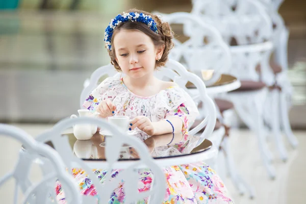 Elégante fille enfant dans une robe florale boire du thé — Photo