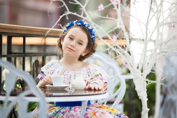 Portrait de petite fille en robe florale buvant du thé — Photo