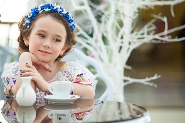 Portrait de petite fille en robe florale buvant du thé — Photo