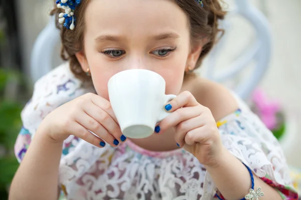 Ritratto di bambina in abito floreale che beve tè — Foto Stock