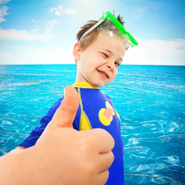 Niño pequeño con pulgares hacia arriba gesto en el mar —  Fotos de Stock