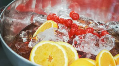 Metal kasede taze meyvelerle karıştırılmış punç.