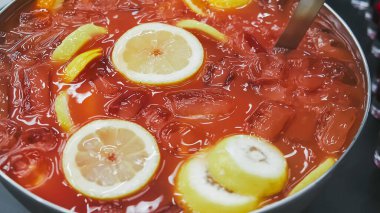 Metal kasede taze meyvelerle karıştırılmış punç.