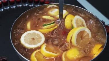 Metal kasede taze meyvelerle karıştırılmış punç.