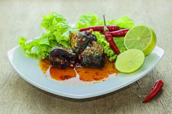 Pescado con salsa de chile en el suelo de madera . —  Fotos de Stock