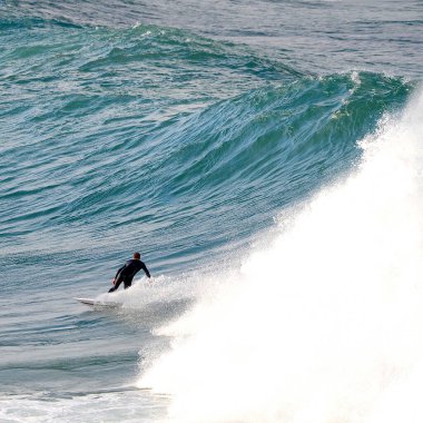 Sydney, Avustralya. Temmuz 2018. Bir sörfçü Sidney, Avustralya 'daki Dee Why Sahili' nde büyük bir dalgaya biniyor..