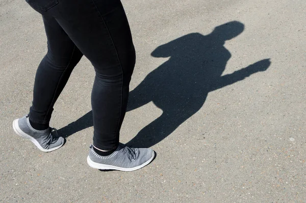 Silhueta Uma Mulher Mostrando Jogging Fundo Asfalto Com Pedras Íngremes — Fotografia de Stock