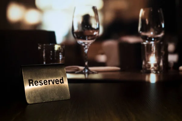 Metalowa Tablica Słowami Reserved Stoi Lewej Stronie Drewnianym Stole Restauracji — Zdjęcie stockowe