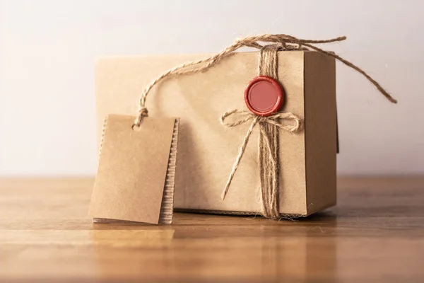 Caja de regalo de cartón artesanal vintage con sello rojo en la mesa de madera Fotos de stock libres de derechos