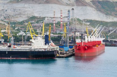 Novorossiysk, Rusya - 4 Ağustos 04: Rusya 'nın Novorossiysk kentindeki Novorossiysk limanındaki dağların arka planına karşı iki kargo gemisi.