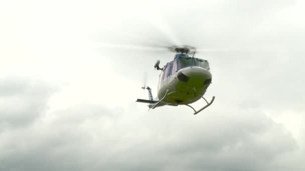 Helikopter vliegt en landt in het landschap. — Stockvideo