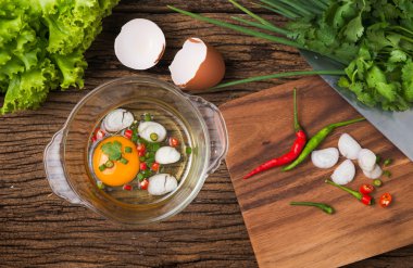 ahşap arka plan üzerinde tavada çiğ yumurta