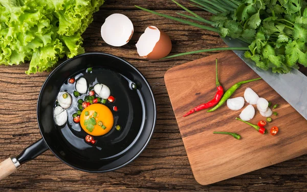 Huevo crudo en sartén sobre fondo de madera — Foto de Stock