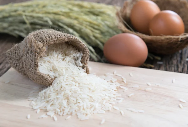 Arroz de jazmín en placa de madera — Foto de Stock