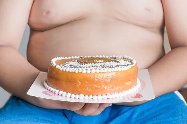 Kuchen in der fettleibigen Hand Junge — Stockfoto