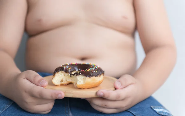 Donut na mão menino gordo obeso . — Fotografia de Stock