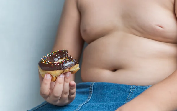Donut in obese fat boy — Stock Photo, Image