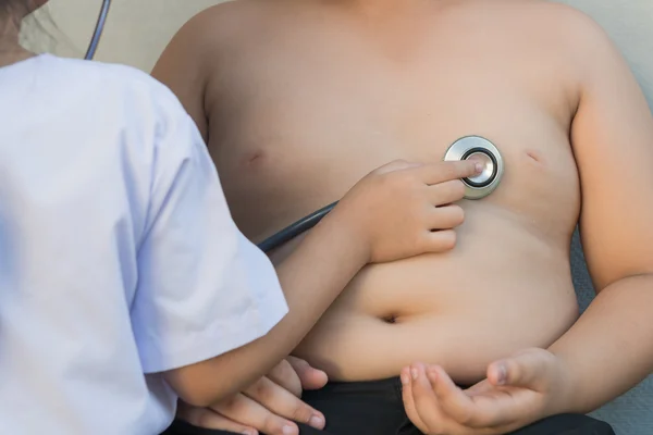 アジアの少年の肥満は、聴診器で心臓をチェックします。 — ストック写真