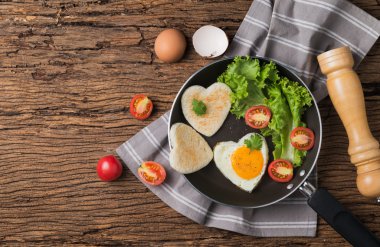 sahanda yumurta ve ekmek bir kalp ve taze sebze şeklinde