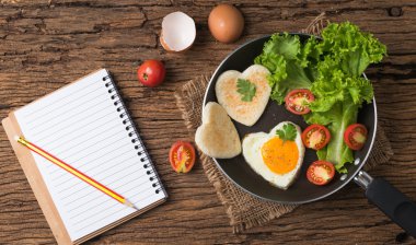 sahanda yumurta ve ekmek bir kalp ve taze sebze şeklinde