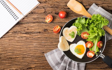 sahanda yumurta ve ekmek bir kalp ve taze sebze şeklinde