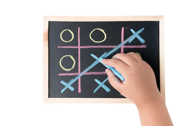 Junge Hand zeichnet ein Spiel von Tic Tac Toe auf einer schwarzen Tafel — Stockfoto