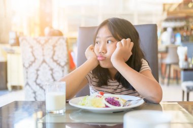 Restoranda sebzelere karşı tiksinti ifadesi olan Asyalı bir kız çocuğu yemek kavramını reddediyor.