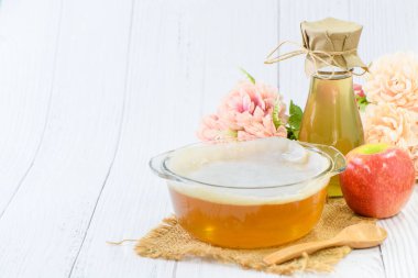 Scoby ve Kombucha çayları ahşap arka planda kase bardakta, elma şarabı mayalanmış içecekler. Kombu çayının faydaları probiyotik kaynağıdır, yüksek antioksidan içerir ve vitamin ve mineral içerir..