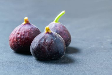 Siyah masa zemininde taze mor incir meyvesi incir yüksek kalsiyum içerir ve antioksidan içerir. Kabızlığı önler ve diyabeti azaltır..