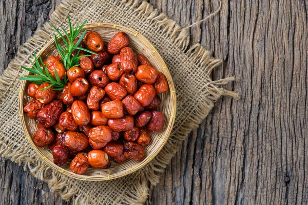 Dried Jujube, Chinese dried red date fruit in bamboo basket on old wood background,herbal fruits. It have more vitamin C Which helps fight free radicals And stimulate the immune system